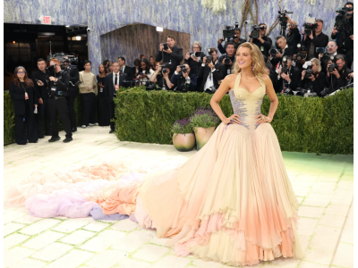 Blake Lively schittert op het Met Gala 2026 in een archiefjurk van Versace met een dramatische sleep in de kleuren van zonsopgang en zonsondergang.